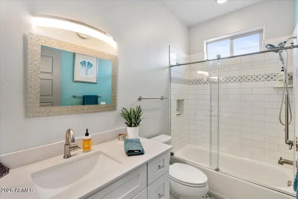 a bathroom with a granite countertop sink a toilet and shower
