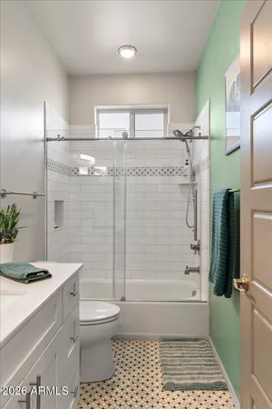 a bathroom with a granite countertop bathtub shower sink and toilet