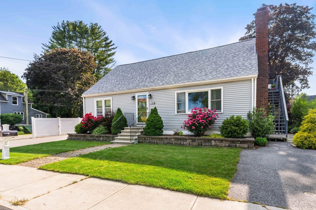 a front view of a house with a yard and potted plants