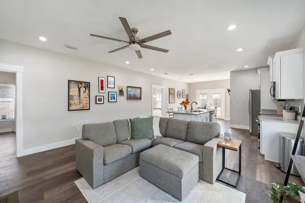 a living room with furniture and a view of kitchen