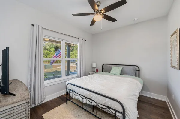 a bedroom with a bed window and a flat screen tv