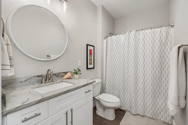 a bathroom with a granite countertop sink mirror vanity and toilet