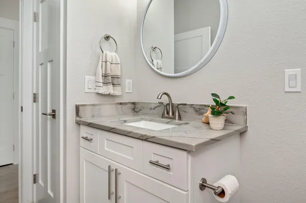 a bathroom with a granite countertop sink and a mirror
