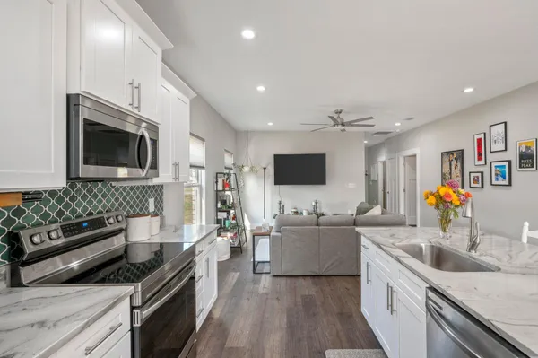 a kitchen with stainless steel appliances granite countertop a sink stove and microwave