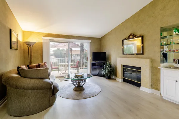 a living room with furniture a fireplace and a flat screen tv