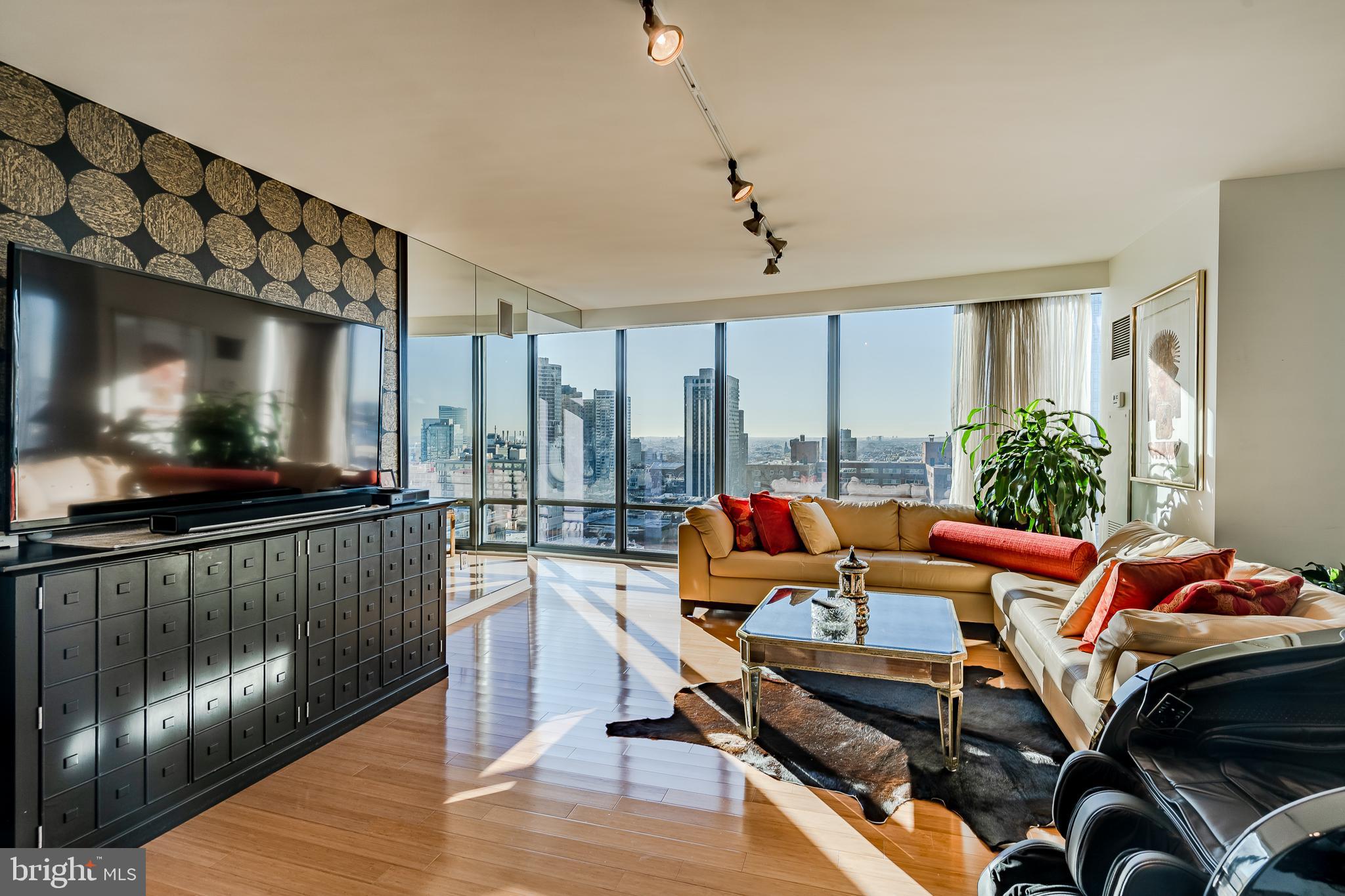 2101-00 Market Street, Unit 1803 Philadelphia, PA 19103 - Photo 8 of 52 a living room with furniture a flat screen tv and floor to ceiling window