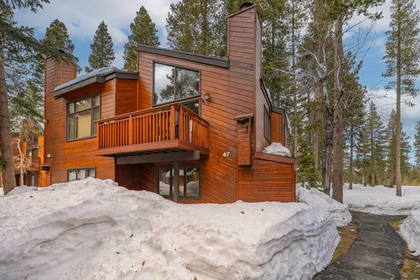 a view of a house with a yard covered in snow