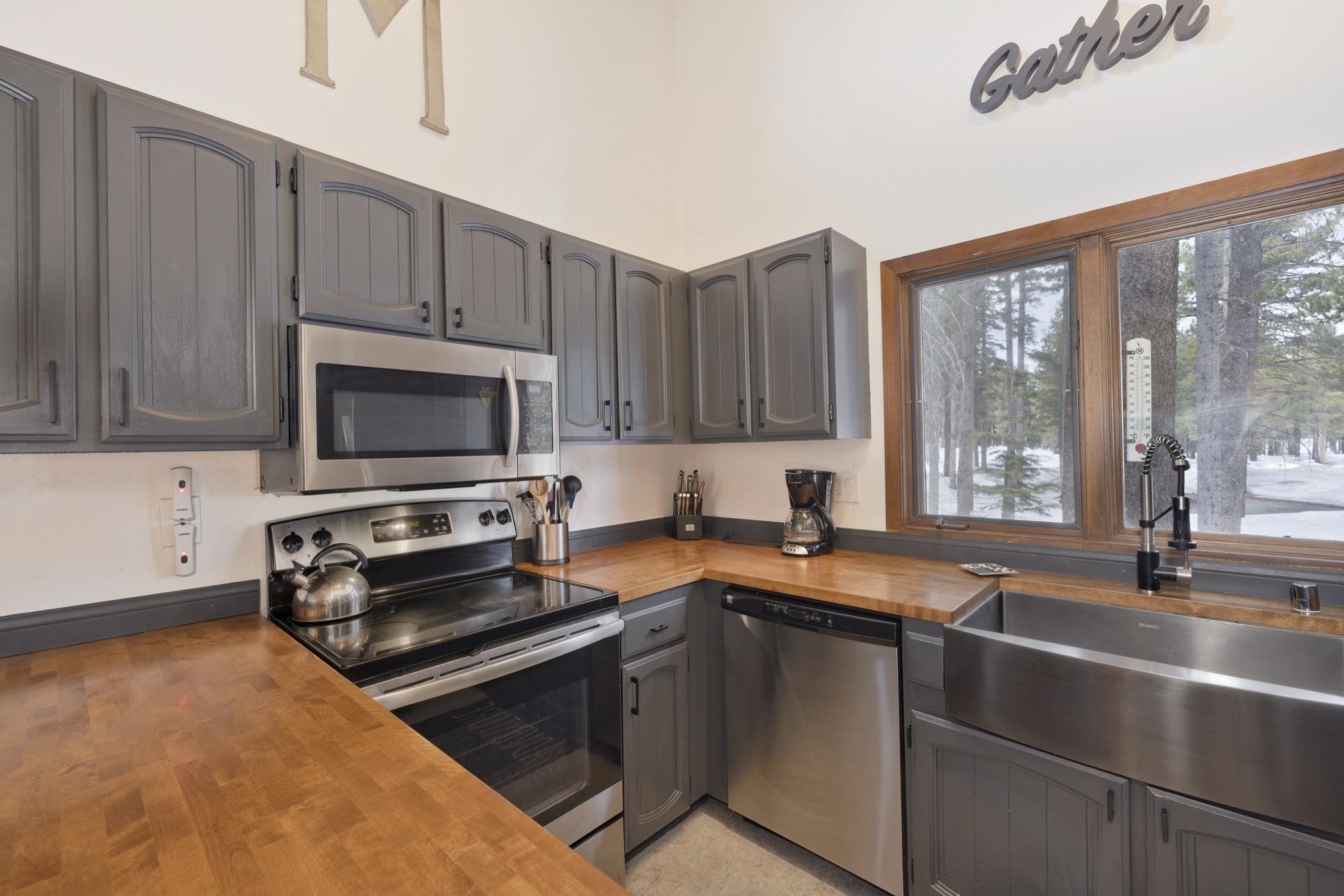 3005 Meridian Boulevard, Unit 47 Mammoth Lakes, CA 93546 - Photo 13 of 40 a kitchen with stainless steel appliances a stove a sink and a microwave