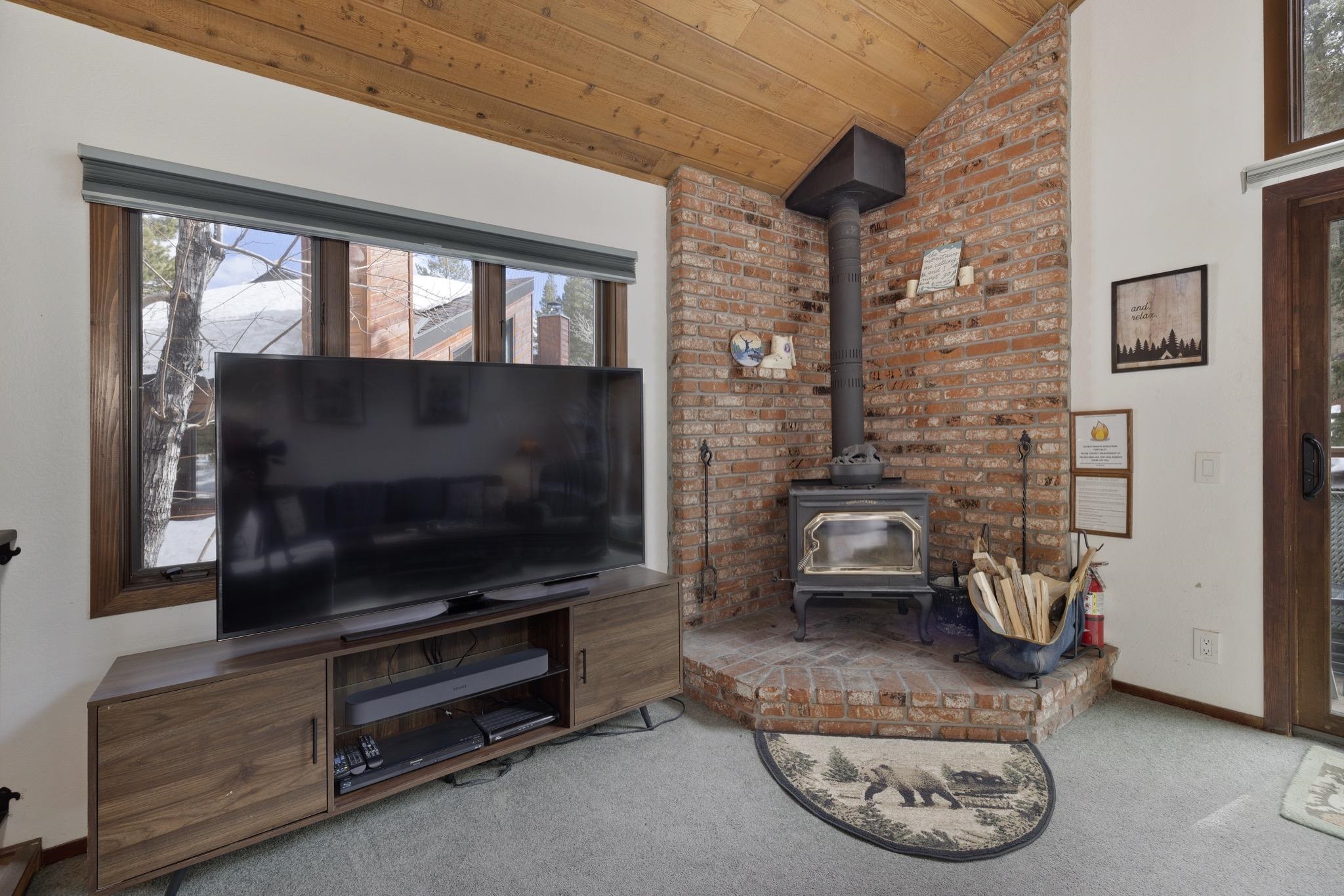 3005 Meridian Boulevard, Unit 47 Mammoth Lakes, CA 93546 - Photo 7 of 40 a living room with furniture a flat screen tv and a floor to ceiling window