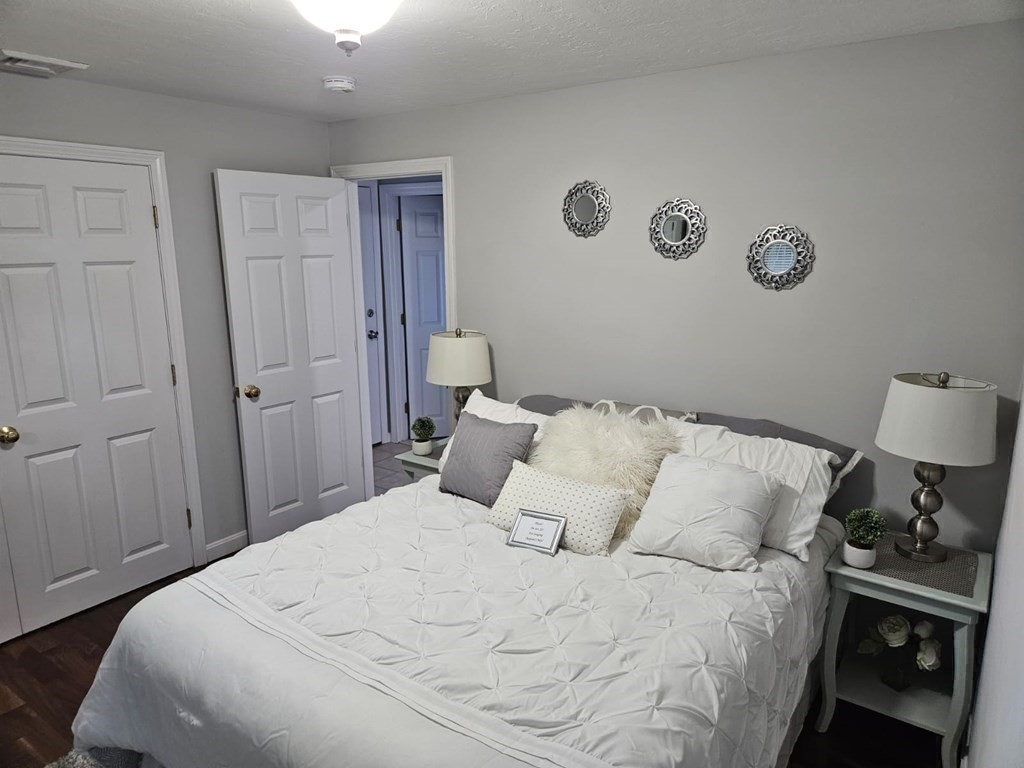 13 Ledge Road Norton, MA 02766 - Photo 8 of 22 a bedroom with a bed and a lamp on dresser