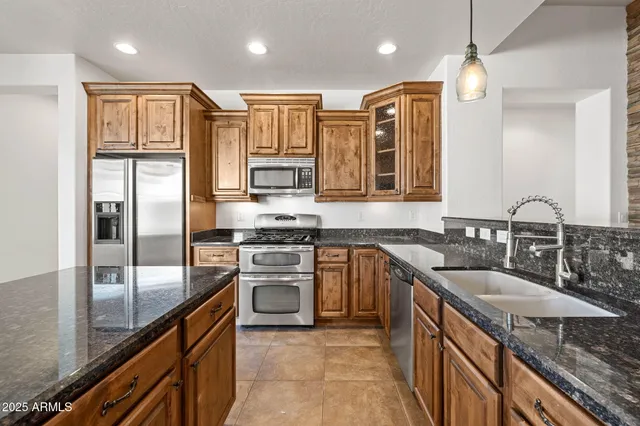 a kitchen with stainless steel appliances granite countertop a refrigerator and a sink