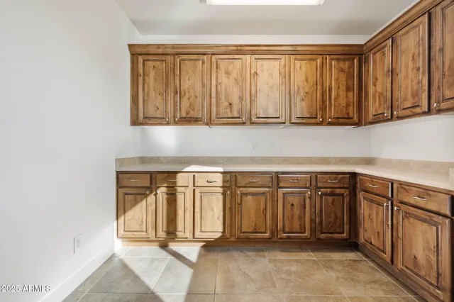 a view of a refrigerator in kitchen and white cabinets