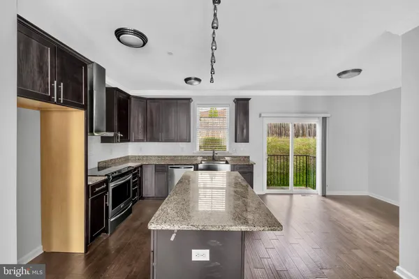 a large kitchen with kitchen island a sink stainless steel appliances and cabinets
