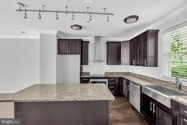 a kitchen with granite countertop a sink stove and cabinets