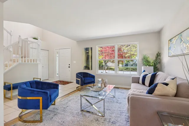 a living room with furniture a rug and a large window
