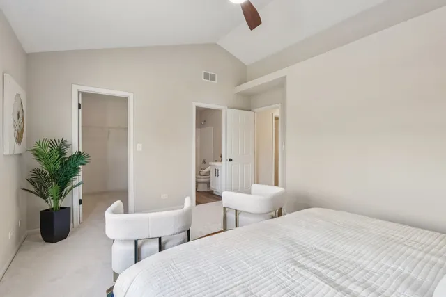 a bedroom with a bed and a potted plant