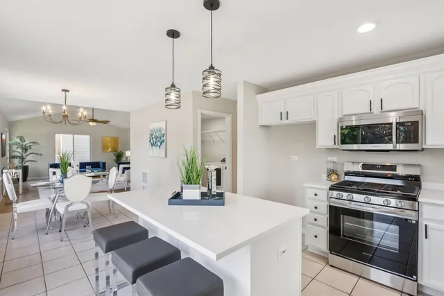 a kitchen with stainless steel appliances a stove a sink a microwave a refrigerator and cabinets