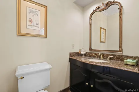 a bathroom with a granite countertop sink mirror and toilet