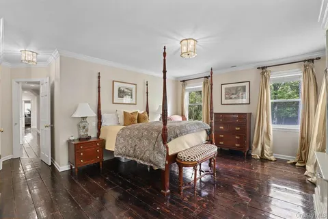 a spacious bedroom with a bed and wooden floor