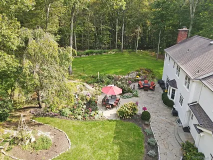 a backyard of a house with a garden and outdoor seating