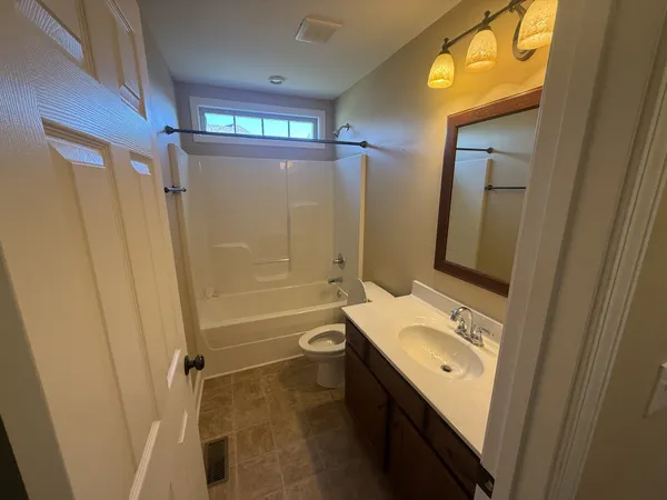 a bathroom with a double vanity sink toilet and shower