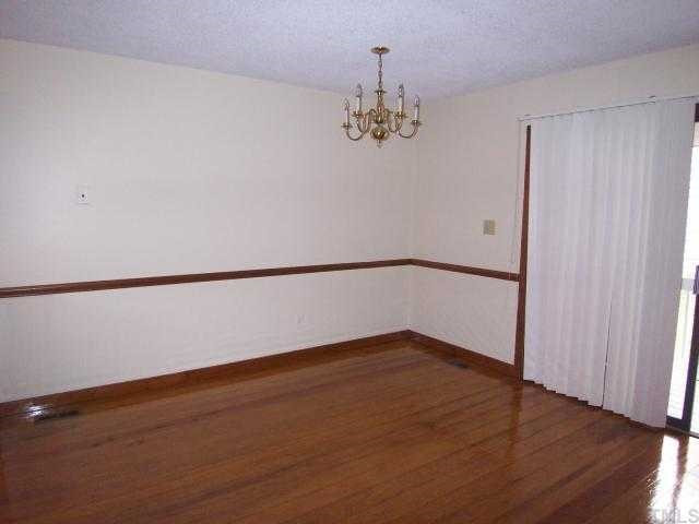 7301 Leesville Road, Unit ABCD Raleigh, NC 27613 - Photo 3 of 8 a view of a room with wooden floor and chandelier