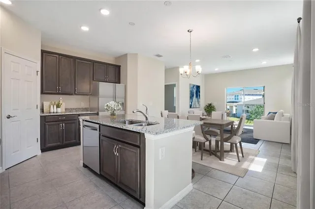 a kitchen with kitchen island granite countertop a sink counter top space appliances and cabinets