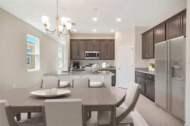 a kitchen with kitchen island granite countertop a sink and refrigerator