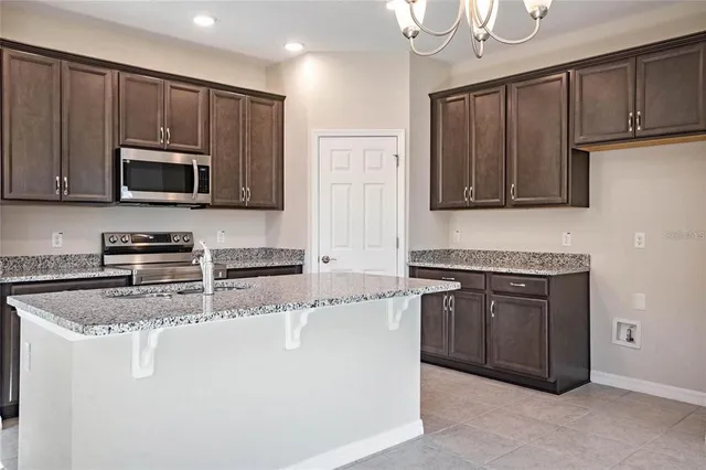 a kitchen with stainless steel appliances granite countertop a stove a microwave and a refrigerator