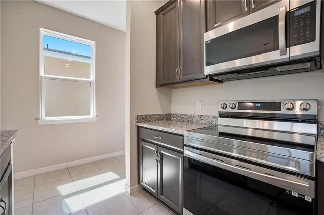 a kitchen with stainless steel appliances granite countertop a stove and a microwave