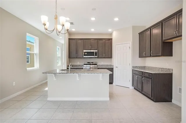 a large white kitchen with a sink and dishwasher