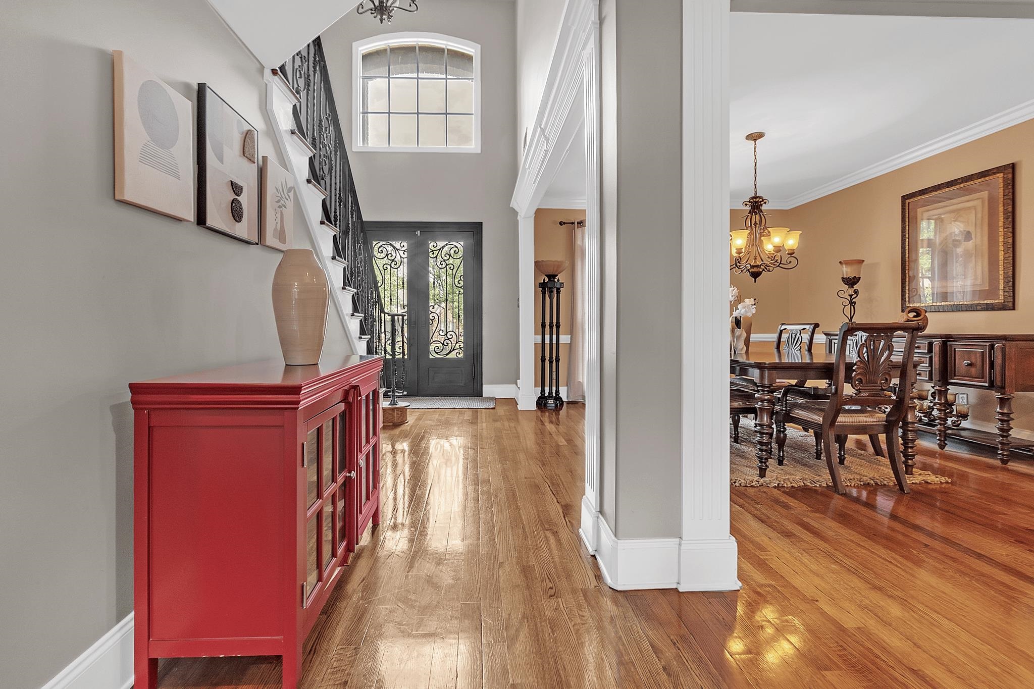649 Ridge Springs Road Collierville, TN 38017 - Photo 6 of 38 Grand entry foyer featuring wood-finish flooring, a double-height ceiling, a decorative iron staircase, and an arched window