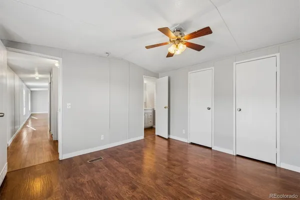 a view of a livingroom with a ceiling fan and wooden floor