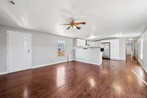 a view of a big room with wooden floor and a ceiling fan