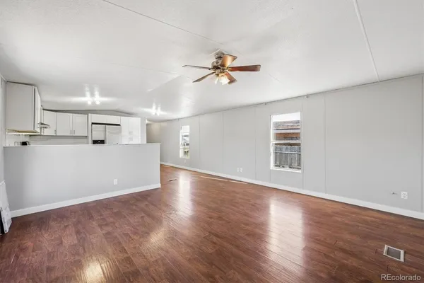 a view of a kitchen with wooden floor and a ceiling fan