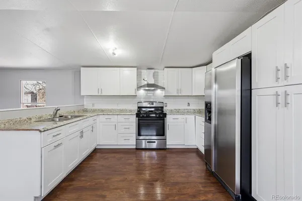 a kitchen with a refrigerator sink and cabinets