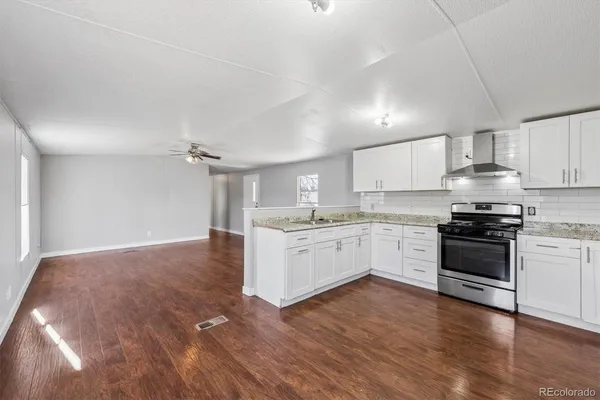 a kitchen with granite countertop white cabinets and stainless steel appliances