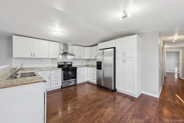 a kitchen with a sink a refrigerator a microwave and cabinets