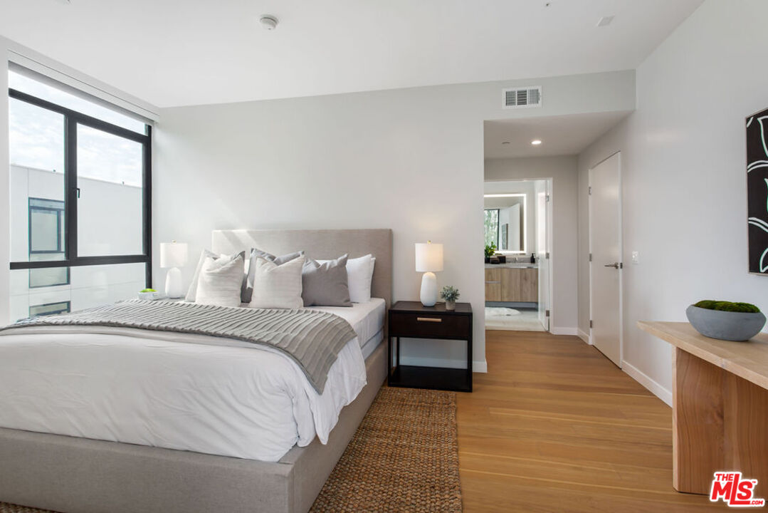 11600 Dunstan Way, Unit 404 Los Angeles, CA 90049 - Photo 16 of 28 a spacious bedroom with a bed and a view of bathroom