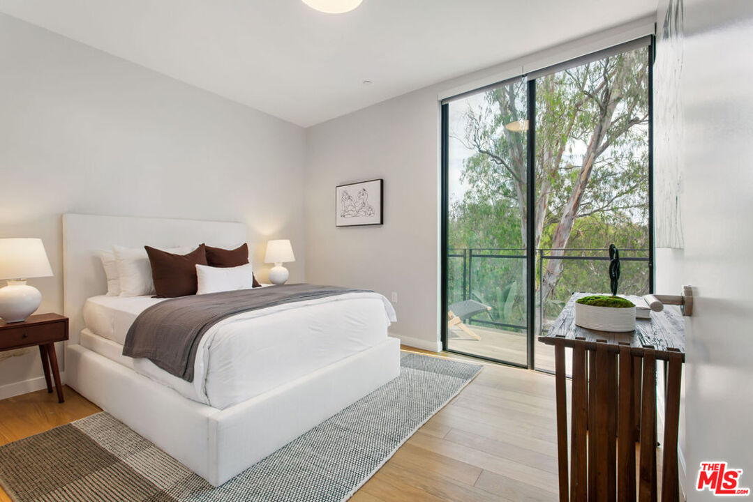 11600 Dunstan Way, Unit 404 Los Angeles, CA 90049 - Photo 22 of 28 a bedroom with a bed and a large window