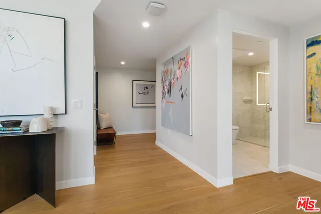 a view of hallway with a large window and a glass door shower