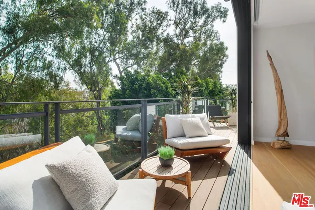 a balcony with couch and a potted plant