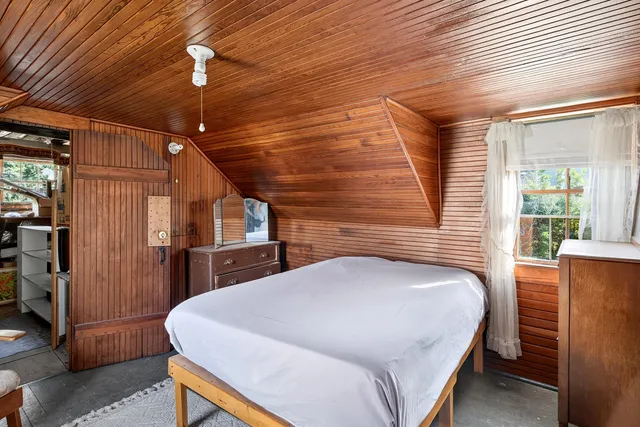 a bedroom with a bed a ceiling fan and a dresser