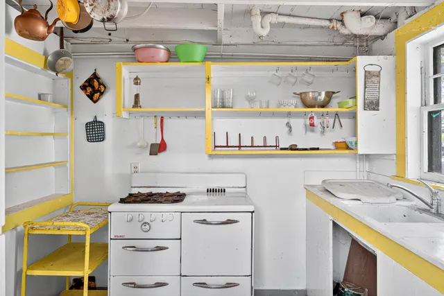 a utility room with stainless steel appliances cabinets and a window
