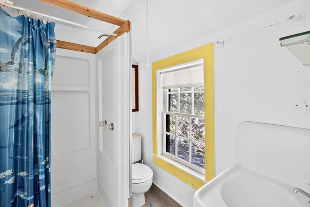 a bathroom with a shower toilet and sink