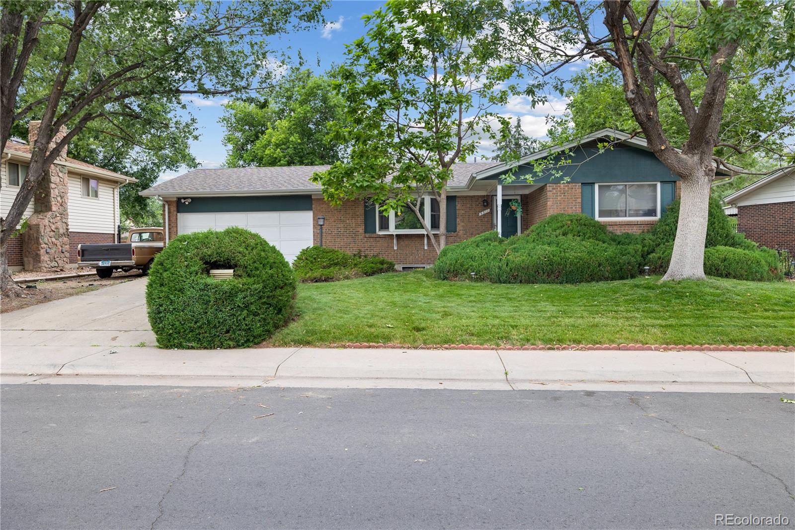 5311 Troy Street Denver, CO 80239 - Photo 1 of 46 a front view of a house with a yard and garage