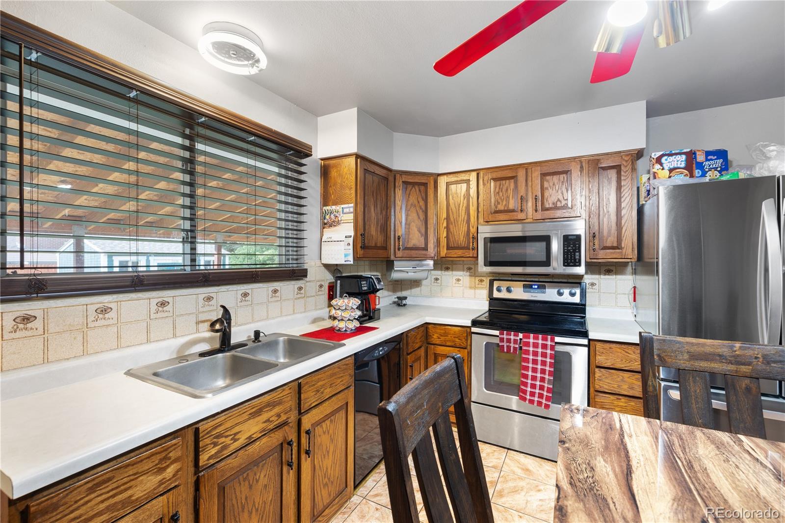 5311 Troy Street Denver, CO 80239 - Photo 11 of 46 a kitchen with stainless steel appliances sink microwave and cabinets