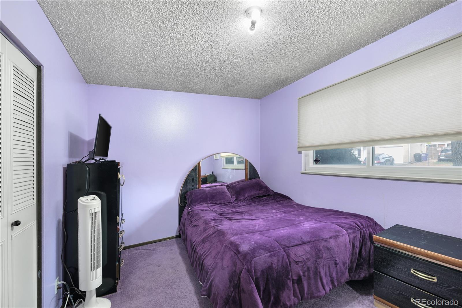 5311 Troy Street Denver, CO 80239 - Photo 16 of 46 a bedroom with a bed and a painting on the wall
