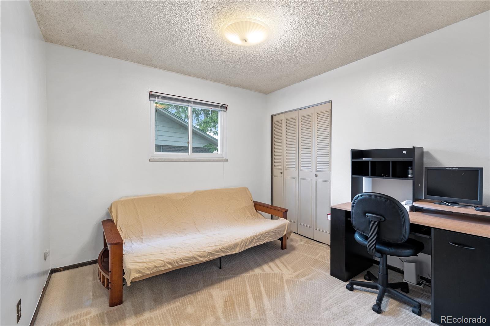 5311 Troy Street Denver, CO 80239 - Photo 20 of 46 a bedroom with a bed and a desk