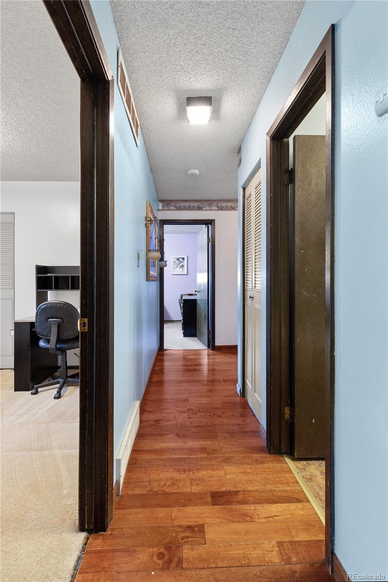 5311 Troy Street Denver, CO 80239 - Photo 22 of 46 a view of a hallway view with wooden floor and furniture